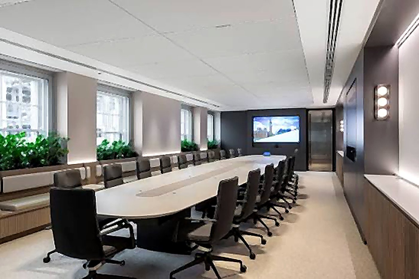 A large boardroom with a long table and front-of-room display